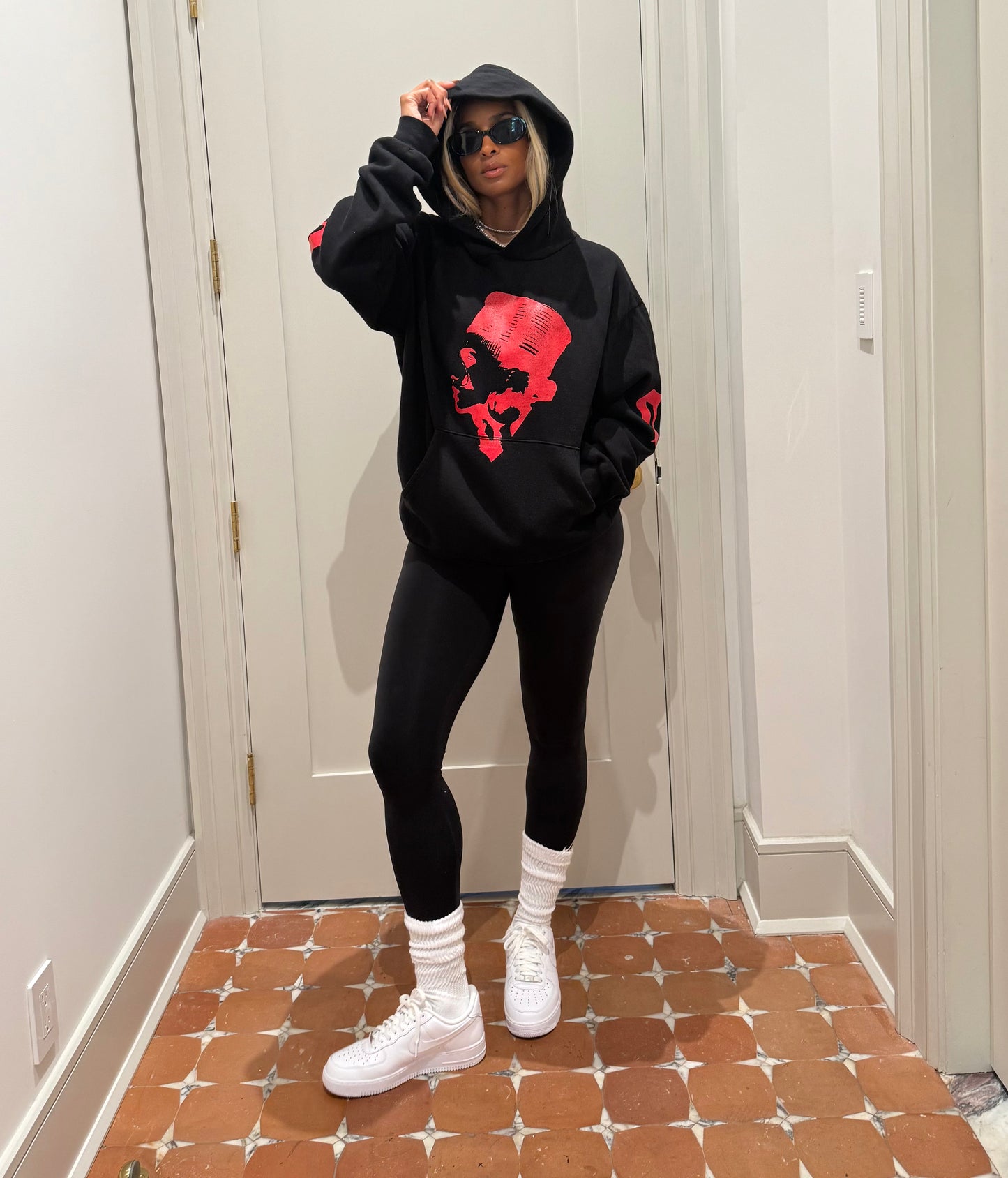 Ciara wearing The CiCi Hoodie. Black hoodie with red graphic design