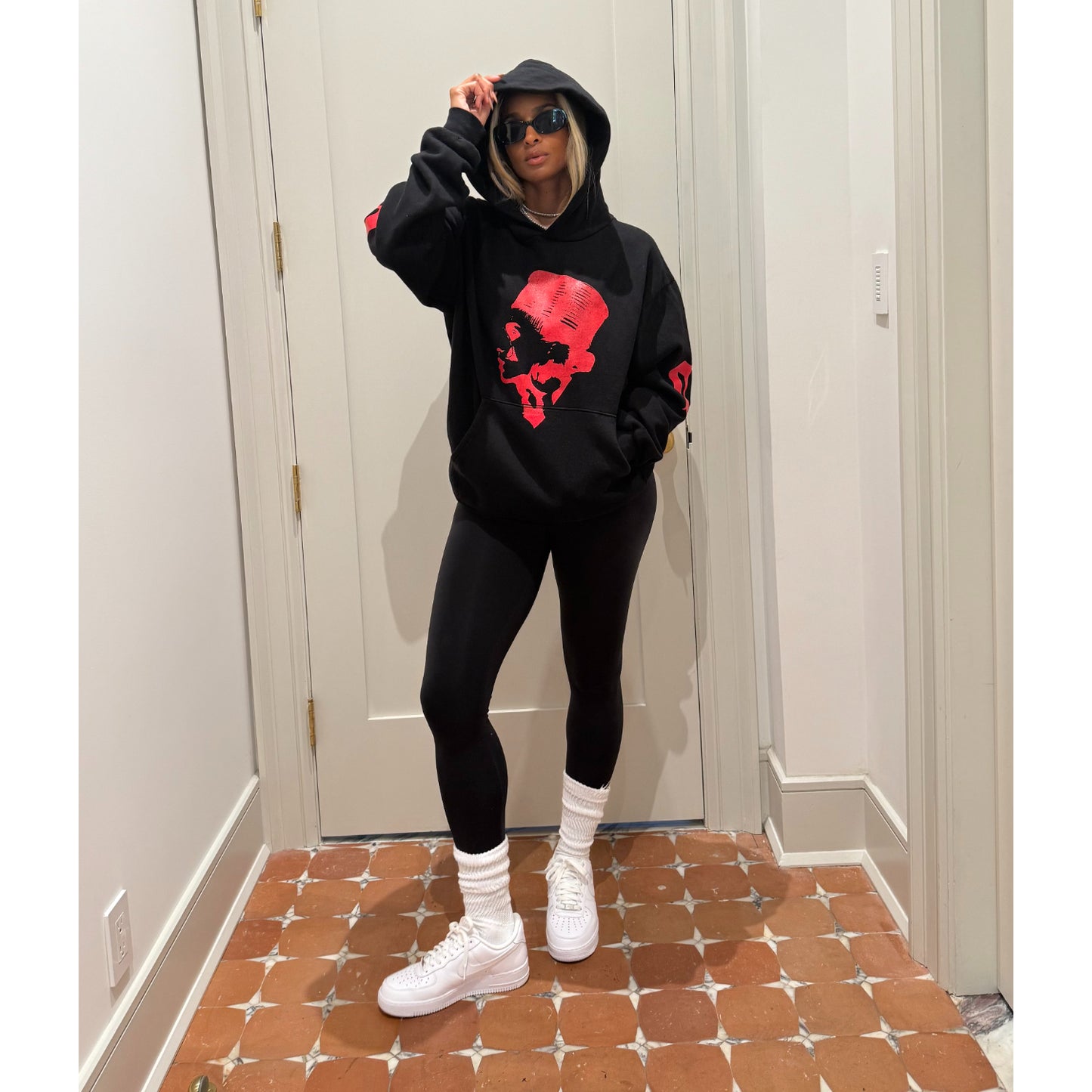 Ciara wearing The CiCi Hoodie. Black hoodie with red graphic design